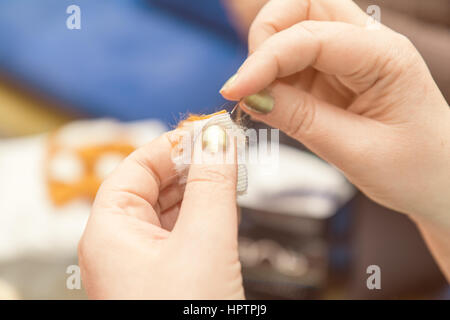 Donna mani maglie pelliccia sintetica pezzi. Close up. La colorazione e l'elaborazione di foto. Foto Stock