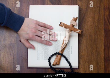 La bibbia, mano e croce Foto Stock