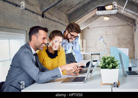 Gruppo di elegante business persone che lavorano insieme in un ufficio moderno Foto Stock