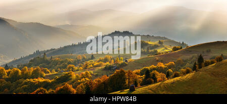 Molla tramonto alpino Bright sole splende sulle colline Foto Stock