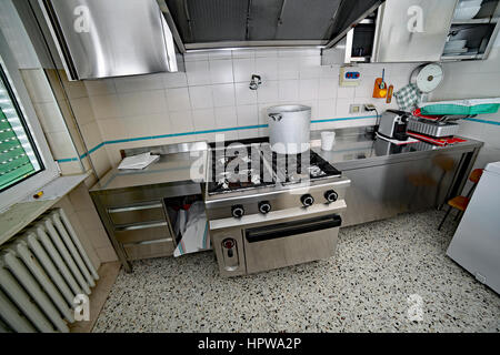 Cucina industriale con mobili in acciaio e una grande pentola in alluminio  sul fornello a gas Foto stock - Alamy