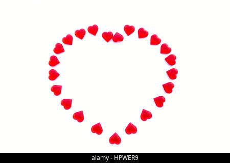 Grande a forma di cuore al di fuori del piccolo acrilico lucido cuori rossi su sfondo bianco con un sacco di spazio copia. Foto Stock