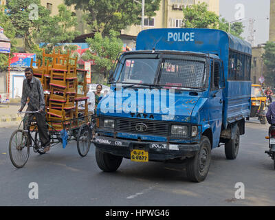 La polizia locale autocarro rendendo il suo modo attraverso la mattina presto il traffico nella città vecchia di Ahmedabad, India Foto Stock