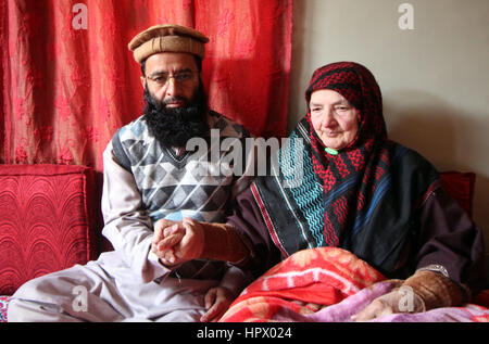 Srinagar, India. 24 Febbraio, 2017. Incontro con lui dopo dodici anni, Fazli della madre per mano del suo 42-anno-vecchio figlio . Sua madre ha sofferto emorragia cerebrale Fazli durante la detenzione in New Delhi e un lato del suo corpo è stato paralizzato. Fazli è 0ne fra i tre giovani del Kashmir che sono stati assolti e rilasciati da un tribunale di New Delhi dopo 12 anni. Essi sono stati arrestati per aver presumibilmente effettuare i blasti di serie a Nuova Delhi nel 2005. Credito: Umer Asif/Pacific Press/Alamy Live News Foto Stock