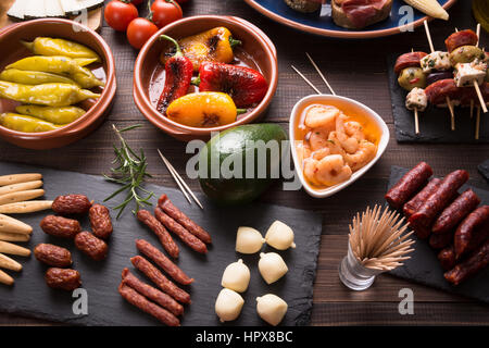 Miscelati tapas spagnoli antipasti in legno marrone scuro e tabella. Vista superiore Foto Stock