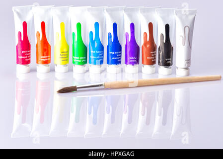 Tubi a spazzola si trova sullo sfondo con vernici di colori differenti sono sulla superficie riflettente Foto Stock