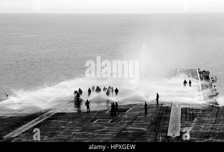 I marinai a bordo della portaerei USS Nimitz prendere parte in un contatore di misurare il lavaggio sul ponte di volo, 15 novembre 2012. Immagine Chris Bartlett/US Navy. Foto Stock