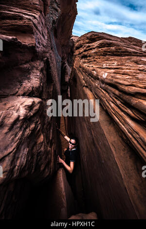 Sorridente escursionista nella crepa nella parete Escalante USA Utah Foto Stock