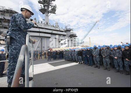 Il cap. Marco Colombo, il delegato della portaerei USS Theodore Roosevelt risolve l'equipaggio sul ponte di volo durante un bi-settimanale esercizio disponibilità, 5 febbraio 2013. Immagine cortesia del Navy US. Foto Stock