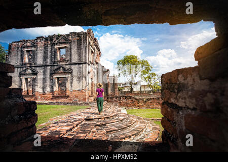 Donna in hat guardando antichi rovinato Tempio della città di Lopburi, Thailandia Foto Stock