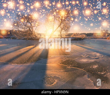 Natale sfondo d'inverno. Nevoso inverno mattina. Sole di mattina si accendono le luci di Natale. Foto Stock