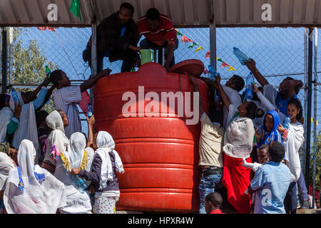 Cristiani etiopi tenere le bottiglie di plastica fino ad essere riempito con acqua santa durante il Timkat (Epifania) Celebrazioni, Addis Abeba, Etiopia Foto Stock