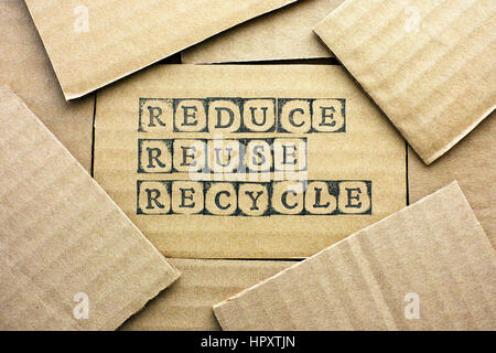 Cartoncino con parole ridurre riutilizzare riciclare realizzato da nero timbri alfabeto con un pezzo di cartone. Foto Stock