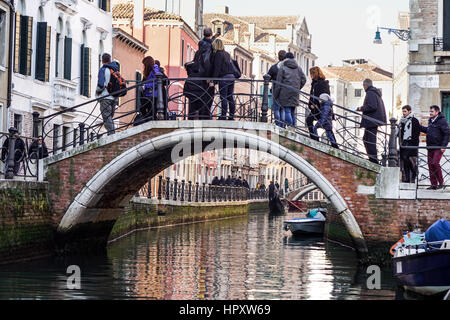 L'Italia, Venezia - 19 dicembre 2016: Le affollate Venezia città crosswalk. Un sacco di persone stanno passeggiando per il lungomare. Su entrambi i lati ci sono diversi Foto Stock