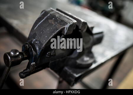 Una offuscata immagine ravvicinata di una morsa in officina. Foto Stock