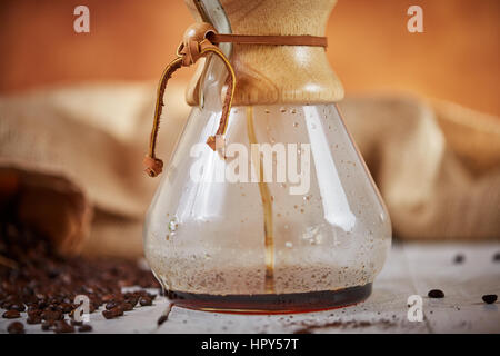 Brewign terza onda caffè con vetro chemex e bollitore antigoccia per puro gusto nel buon design sul tavolo di legno Foto Stock