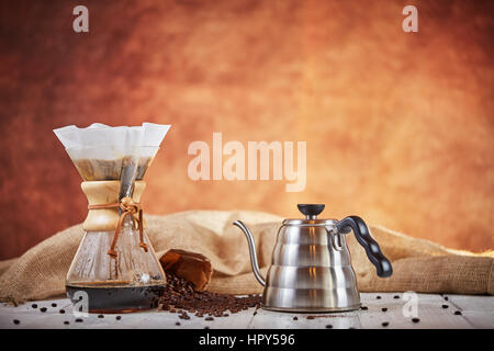 Brewign terza onda caffè con vetro chemex e bollitore antigoccia per puro gusto nel buon design sul tavolo di legno Foto Stock