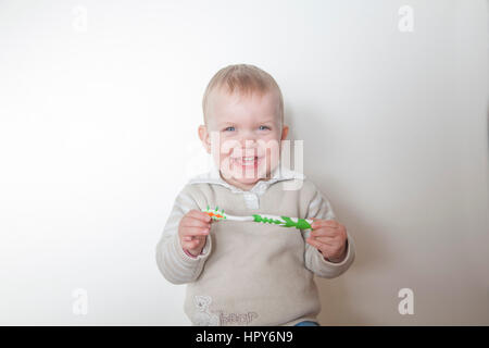 Bambina spazzolare i suoi denti isolati su sfondo bianco Foto Stock