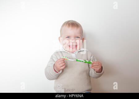 Bambina spazzolare i suoi denti isolati su sfondo bianco Foto Stock