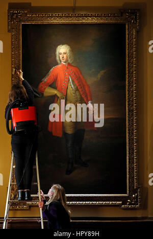 Un conservatore pulisce la cornice dorata tenendo un ritratto del tenente colonnello John Copel durante la pulizia di primavera a Blickling Hall nel Norfolk prima della casa è riaperto al pubblico il 6 marzo. Foto Stock