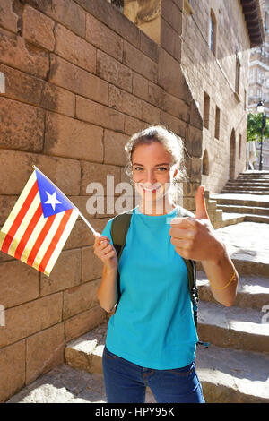 Funny attraente ragazza mostra il pollice in su. Giovani turisti con una bandiera spagnola durante un viaggio al sole della Spagna. Escursionismo. Foto Stock