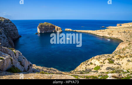 A Gozo, Malta - panoramica vista sullo skyline di Dwejra Bay con la roccia del fungo, Azure Window e la barca a vela su una bella e calda giornata d'estate Foto Stock