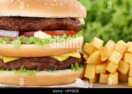 Double burger hamburger con patatine fritte closeup close up carni bovine i pomodori lattuga insalubre di formaggio Foto Stock