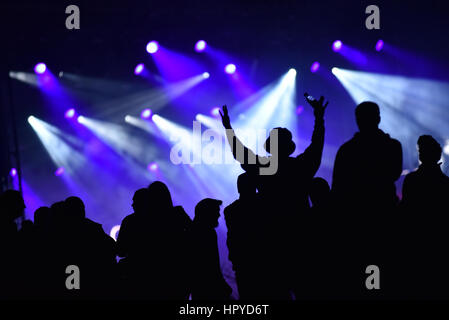 Sagome di concerto la folla di fronte luminose luci da palco Foto Stock