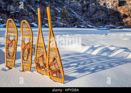 In legno vintage Huron e Bear Paw racchette da neve con rilegatura in pelle nella neve con ombra Foto Stock