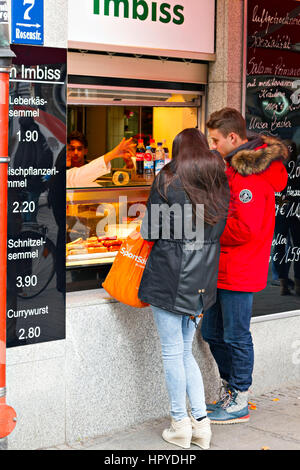 Coppia giovane acquisto di fast food da un lato della strada shop, Monaco di Baviera, Baviera, Germania, Europa Foto Stock