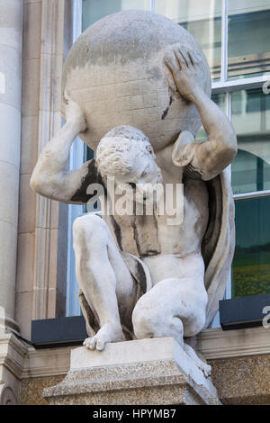 Una scultura di un uomo che porta una sfera sulla sua schiena, sulla facciata di un edificio nella città di Londra, Regno Unito. Foto Stock