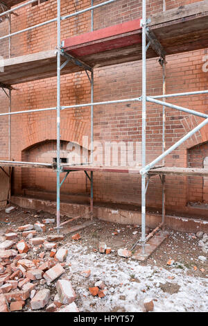 Ponteggio a storico muro di mattoni di edificio attualmente sotto la riqualificazione Foto Stock