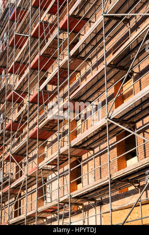 Ponteggio a storico muro di mattoni di edificio attualmente sotto la riqualificazione Foto Stock