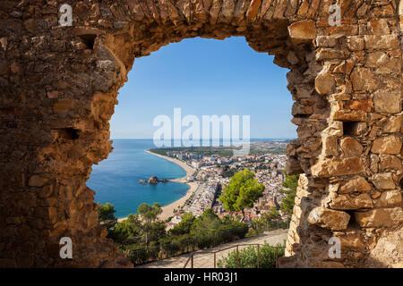 Blanes resort costiero città in Spagna, incorniciato sopra vista attraverso il foro in una parete di San Giovanni Castello Foto Stock