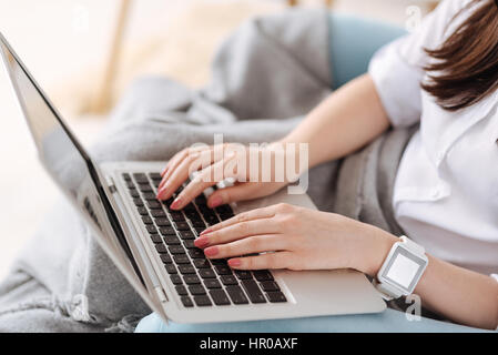 Lavorare su un laptop. In prossimità di una bella bella bella donna che mantiene un notebook e premendo i pulsanti durante la digitazione di un testo Foto Stock