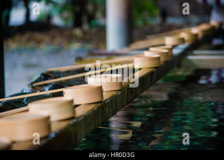 Acqua di mestoli e campionatori a immersione in legno utilizzati per un cerimoniale di purificazione in ingresso del santuario Foto Stock