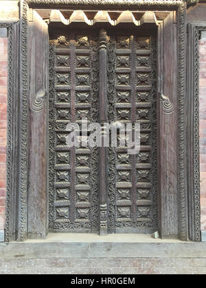 Antico in pietra e boschi carving con gli indù simbolo per fare leva in Bhaktapur, luogo di devoti. Noto anche come Bhadgaon o Khwopa, un antico Newar. Foto Stock