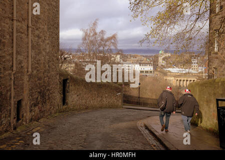 Edinburgh il tumulo due turisti di camminare sulla strada vista città al di sotto di Foto Stock