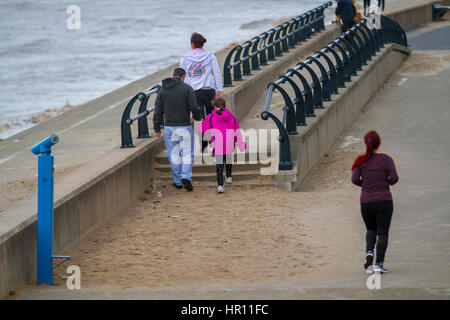 Southport, Merseyside, Regno Unito. Meteo. Il 26 febbraio, 2017. Asciutto e caldo al 10C come i residenti locali approfittare della pausa in tempo per godere di una gita sulla spiaggia a marea alta. Allarme tempesta di pioggia e 70mph venti sono stati rilasciati per la costa ovest dell'Inghilterra. Il Met Office ha rilasciato un giallo "essere consapevole' avvertenza per grandi parti del Regno Unito dalle 11.00 di domenica. Credito: MediaWorldImages/AlamyLiveNews Foto Stock