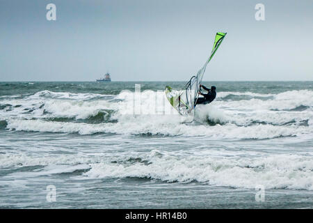 West Wittering beach, West Sussex. Il 26 febbraio 2017. Condizioni di bassa pressione ha portato al vento e le onde sulla costa sud dell'Inghilterra di oggi. Un windsurf godendo le condizioni a West Wittering beach in West Sussex. Credito: James jagger/Alamy Live News Foto Stock