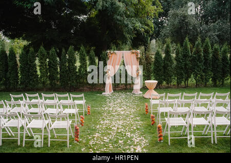 Splendido arco di nozze. Arch decorate con panno che ricordano le pesche e fiori Foto Stock