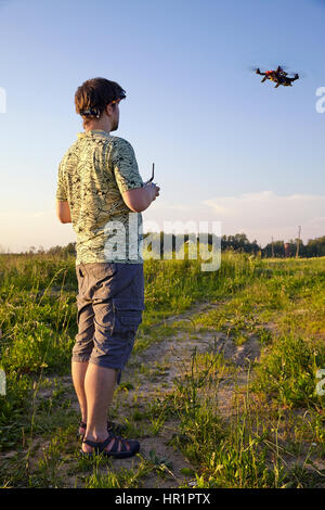 Padre e figlio controlla RC drone quadrocopter nel cielo Foto Stock