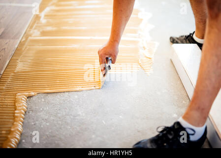 Operaio industriale aggiunta di colla sul pavimento di cemento, preparare  la superficie per parquet in legno Foto stock - Alamy