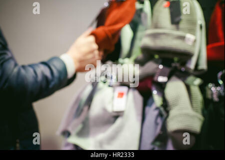 Abstract di sfocatura dello sfondo uomo sceglie cappelli in negozio Foto Stock