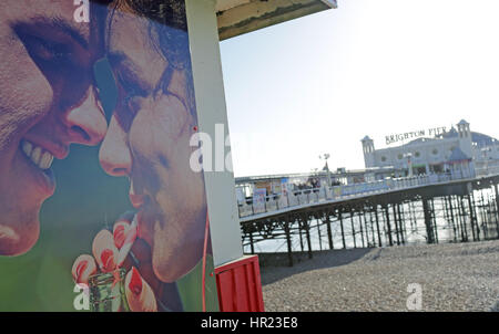 Il poster di un uomo e di una donna accanto al Palace Pier Brigton Foto Stock