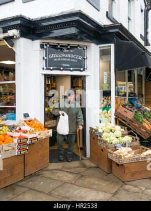 Un vecchio uomo che esce da un fruttivendolo in negozio con un sacchetto di verdure in thirsk North Yorkshire Foto Stock