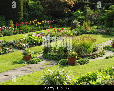 Chenies Manor Sunken garden in tulip time; una bella serata di maggio con il sole e il fresco verde per la crescita di piante. Foto Stock