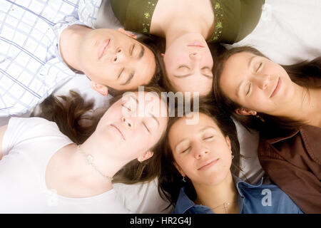 Amici con teste insieme mentre dorme sul pavimento - soft focus Foto Stock