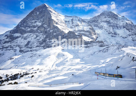 Treno a Kleine Scheidegg sotto Eiger, Monch e Jungfrau picchi nelle Alpi svizzere, Berner Oberland, Grindelwald, Svizzera. Foto Stock