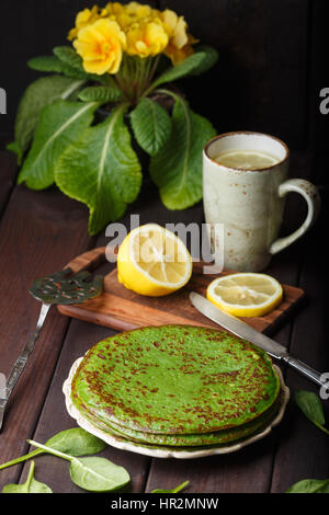 Frittelle di spinaci sul tavolo di legno e giallo primrose. Foto Stock